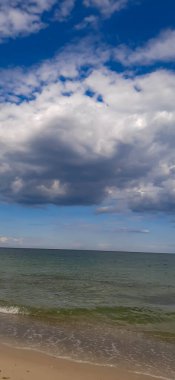 Karadeniz 'in yüzeyinde çok güzel bulutlar var. Sakin deniz ve ışık bulutlu bir gökyüzünde sörf yapıyor..