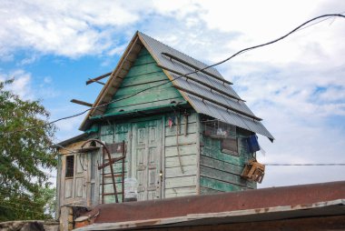 Dovecote on the roof of the garage.Wooden dovecote against the sky. House for housing pedigree pigeons. clipart