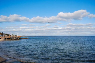 Karadeniz kıyısındaki Odessa Körfezi, Otrada Sahili. Paslanmış bir iskele ve gökyüzünde bir martı. Kıyı şeridi uzaklıktan görülebiliyor - Kotovsky yerleşimi orada bulunuyor..