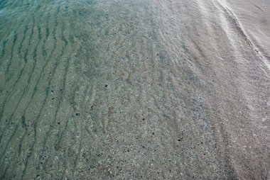 The sandy bottom of the Black Sea at the surf line.The transparent water of the Black Sea in winter allows you to see the sandy bottom well. clipart