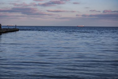 Karadeniz 'in Odessa Körfezi. Bulutlu bir günde, Karadeniz Odessa 'nın kumlu sahillerine küçük dalgalar halinde yuvarlanıyor..