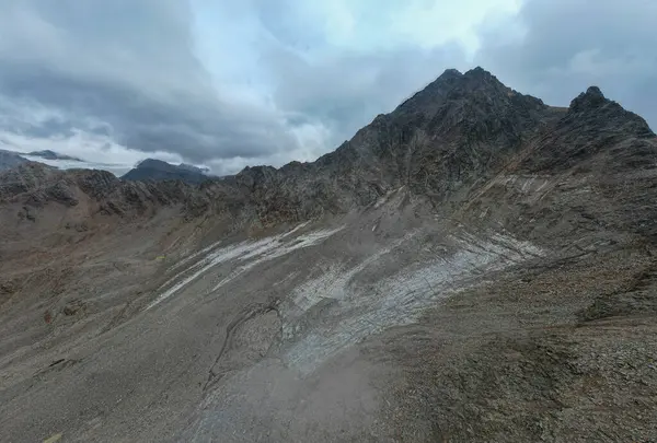 Dağların zirvesinde bulutların arasında, arka planda güzel bir dağ var.