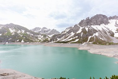 Güzel bir göl manzarası ve arka planda dağlar
