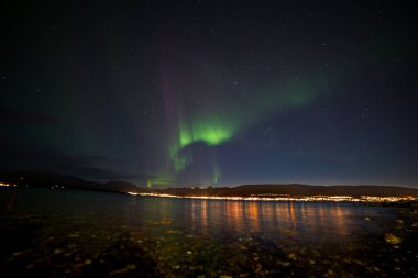 Norveç 'te göl ve dağların üzerinde Aurora Borealis