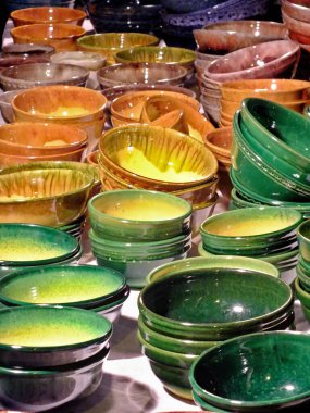 Beyaz bir masada çok renkli kil tabaklar..