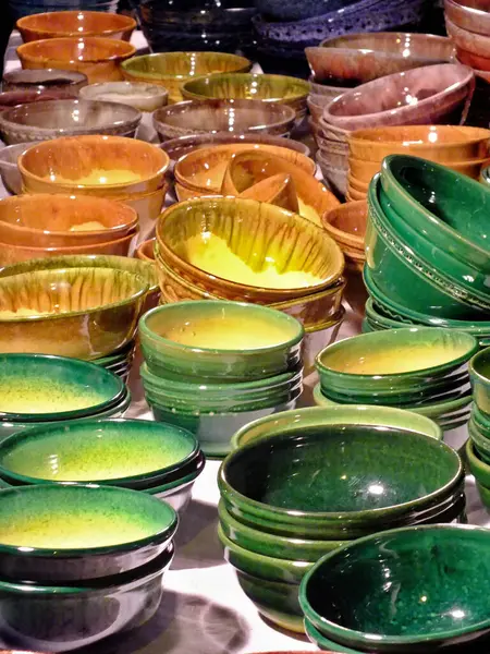 Beyaz bir masada çok renkli kil tabaklar..