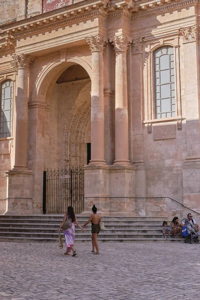 Manacor, İspanya; 2 de julio de 2019: Dos chicas pasean por una calle antigua cogidas de la mano como muestra de amor.