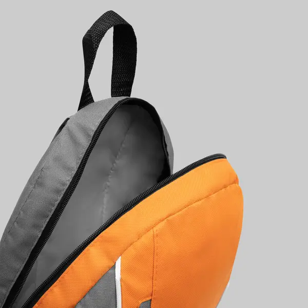 Beyaz arka planda fermuarı ve omuz kayışları olan boş bir sırt çantası. Sırt çantasıyla seyahat. Okul naylon çantasını katlıyorum. Üst görünüm modeli.