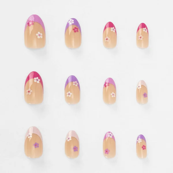 Beyaz arka planda izole edilmiş renkli sahte tırnak yapıştırıcısı seti. Üst Manzara. Kadınlar için takma tırnaklar. farklı moda tırnak şekilleri.