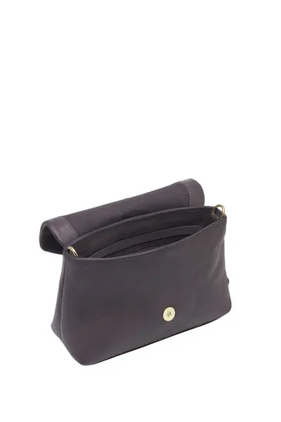 Açık kapaklı ve altın tokalı kahverengi deri bir çanta temiz beyaz bir arkaplan ile sunuluyor. Atış çantaların tarzını ve tasarımını vurguluyor.