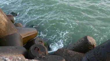 Ventspils dalgakıran rıhtımında Baltık Denizi kucaklaşması - gün batımında kayalık bir serenat. Solda kopyalama alanı ile görüntüle.