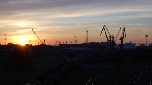 Panorama Der Industriellen Sonnenuntergangssilhouette Mit Kränen Und Frachtausrüstung Vor Einem — Stockvideo