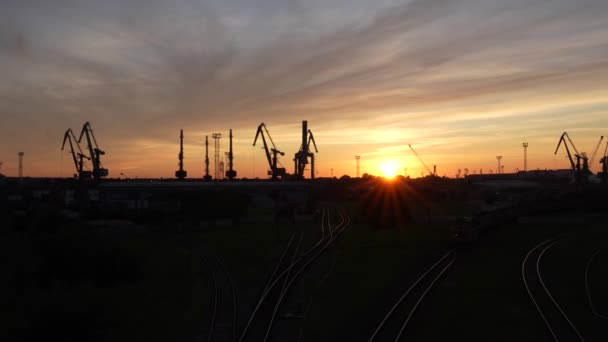 在生机勃勃的天空中看到起重机和铁轨轮廓的工业景观 — 图库视频影像