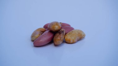 İlk filizleri gösteren pembe fasulyeler, belirgin renk kalıplarıyla erken büyümeye yakın. Filizlenmenin ilk belirtilerini gösteren pembemsi fasulye yığını.