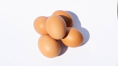 Beyaz arka planda ince bir gölgesi olan sade kahverengi yumurta