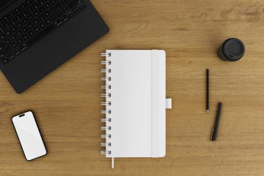 Defter ve telefon ahşap bir masanın üstünde.