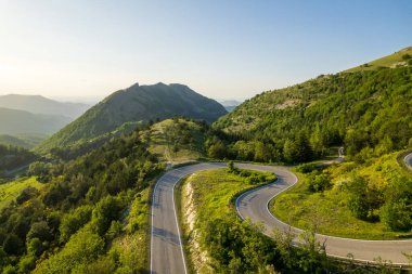 İtalya 'nın Marche bölgesinde Monte Nerone yamacındaki kavisli yol manzarası