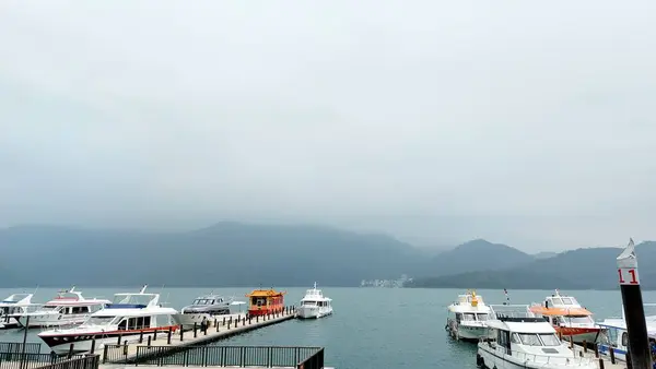 Göldeki teknenin dağ ve gökyüzü arkaplanlı manzarası.