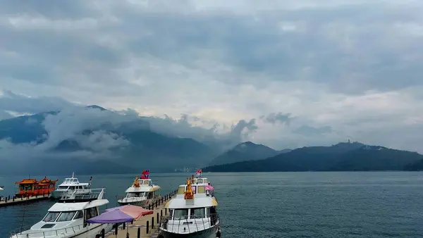 Göldeki teknenin dağ ve gökyüzü arkaplanlı manzarası.