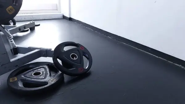 Spor salonunda plaka dolu bir makinede demir levhalar.