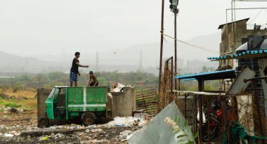 Kırsal Hindistan 'da çöplükte çöpleri karıştıran adamlar.