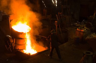 Metalürjist sıcak erimiş metalden gevşetir.