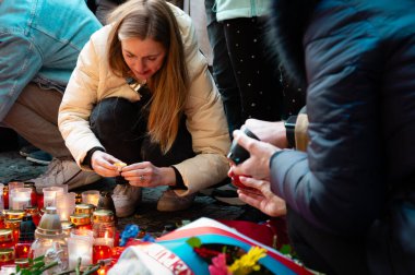 Narodni Trida 'nın 17 Kasım 1989 tarihli anma plaketinde mum yakan bir kadın.