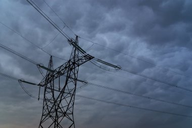 Fırtınalı gökyüzünün altındaki elektrik hatları
