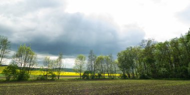 Çek Cumhuriyeti kırsalında, bir tarla üzerinde bahar fırtınalı gökyüzü