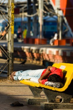 Chhatrapati Shivaji İstasyonu 'nda bir bankta uyuyan genç adam.