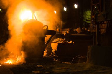 Bir dökümhanede maden arabasının yanında erimiş sıvı metal soğutma.