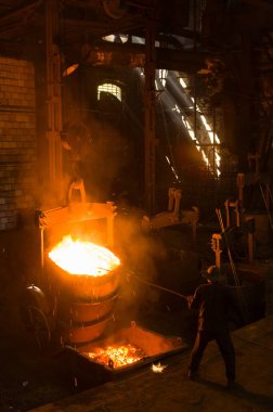 Metalürjist sıcak erimiş metalden gevşetir.