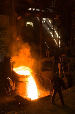 Metalürjist sıcak erimiş metalden gevşetir.