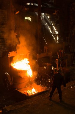 Metalürjist sıcak erimiş metalden gevşetir.