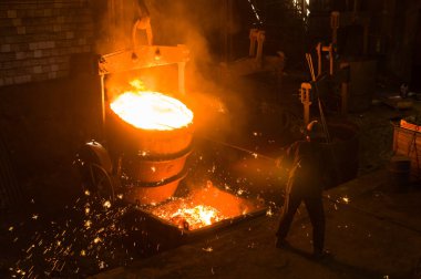 Metalürjist sıcak erimiş metalden gevşetir.