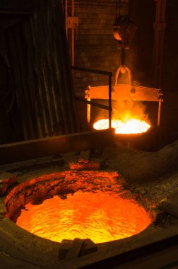 Dökümhanede parlayan sıcak sıvı metalin yakınlaştırılması