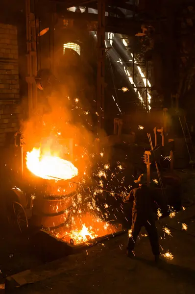 Metalürjist sıcak erimiş metalden gevşetir.