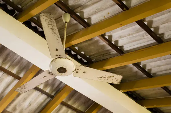 Asbest bir çatı altında asılı eski tavan fan