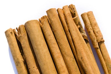 Beyaz bir arka plan üzerinde izole kuru tarçın haddelenmiş