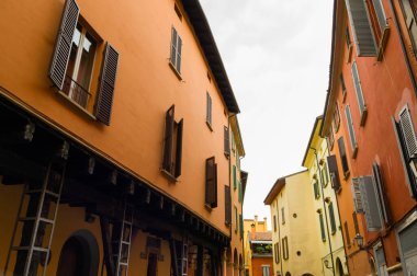 Renkli cephe ve ahşap pencere kepenkleri ile dar sokak