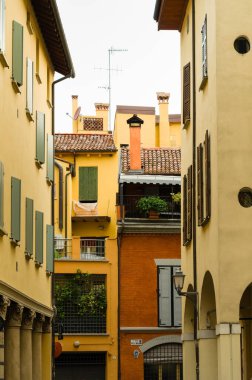 Renkli cephe ve ahşap pencere kepenkleri ile dar sokak