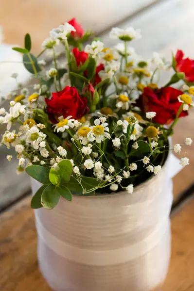 Bouquet of small flowers arranged in a white tin vase