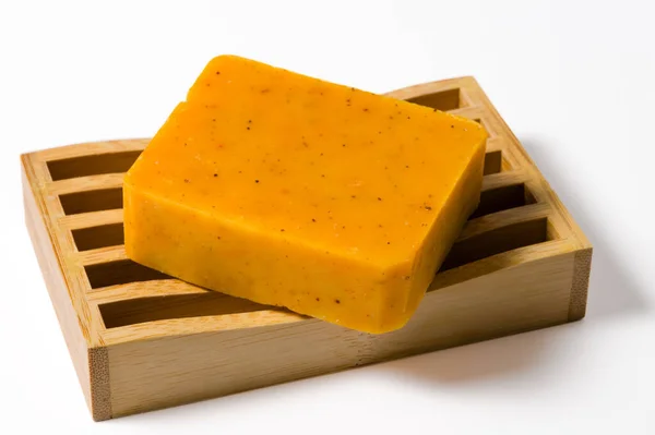 Beyaz arka planda izole edilmiş bambu sabun tepsisindeki el yapımı organik sabunlar.