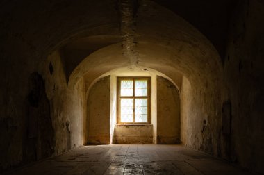 Pencere ve ahşap zeminli terk edilmiş barok tarzı bir oda.
