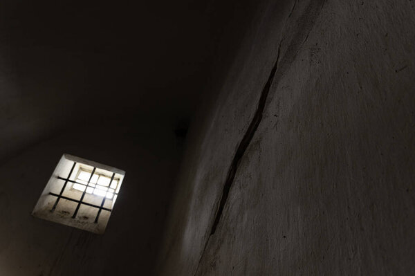 Barred window in a an old solitary confinement cell