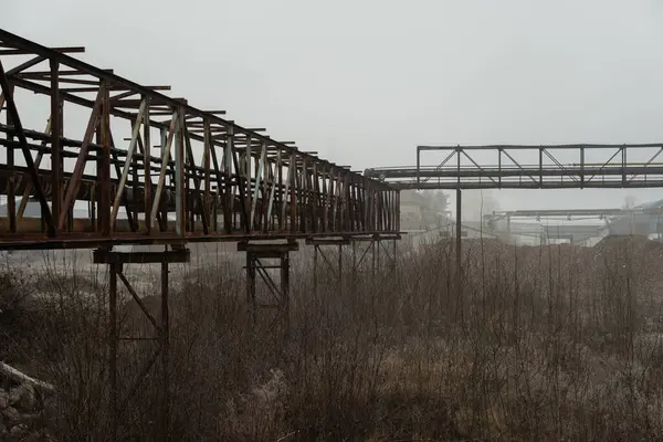 Sisli bir kış gününde terk edilmiş bir sanayi bölgesinde borular ve borular.