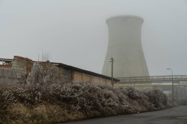 Massive concrete cooling tower in an abandoned industrial area clipart