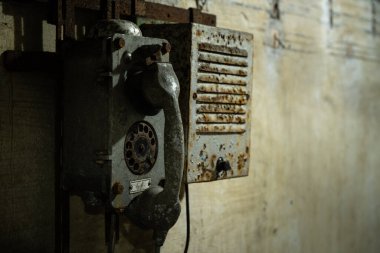 Çek Cumhuriyeti 'nde terk edilmiş bir maden tünelinin içindeki beton duvarda eski bir telefon ve dahili telefon var..