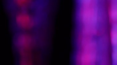 Siyah bir arkaplan üzerinde soyut dönen cam RGB ışık yansımaları.