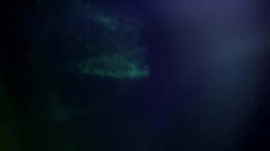 Soyut yeşil ve mavi ışık siyah arkaplan üzerindeki yansımaları sızdırır. 